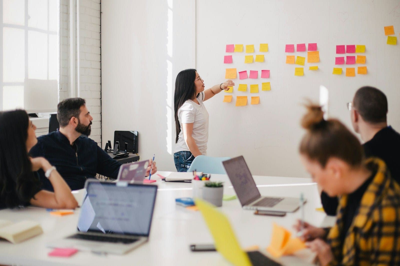 Small team planning around a wall of sticky notes