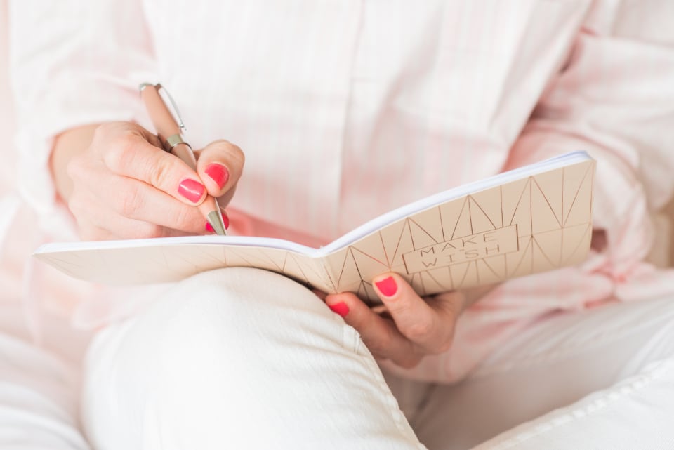 Woman writing in a notebook on her lap