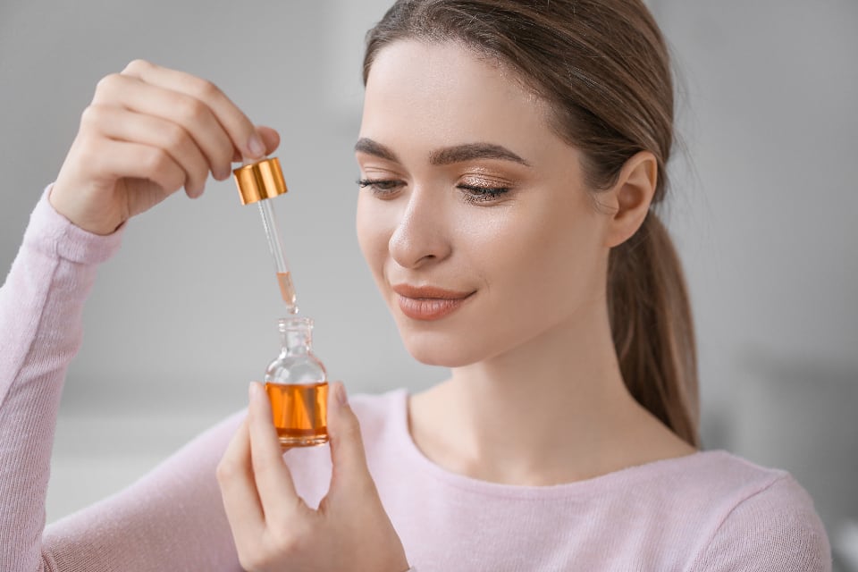 Woman holding a serum dropper bottle
