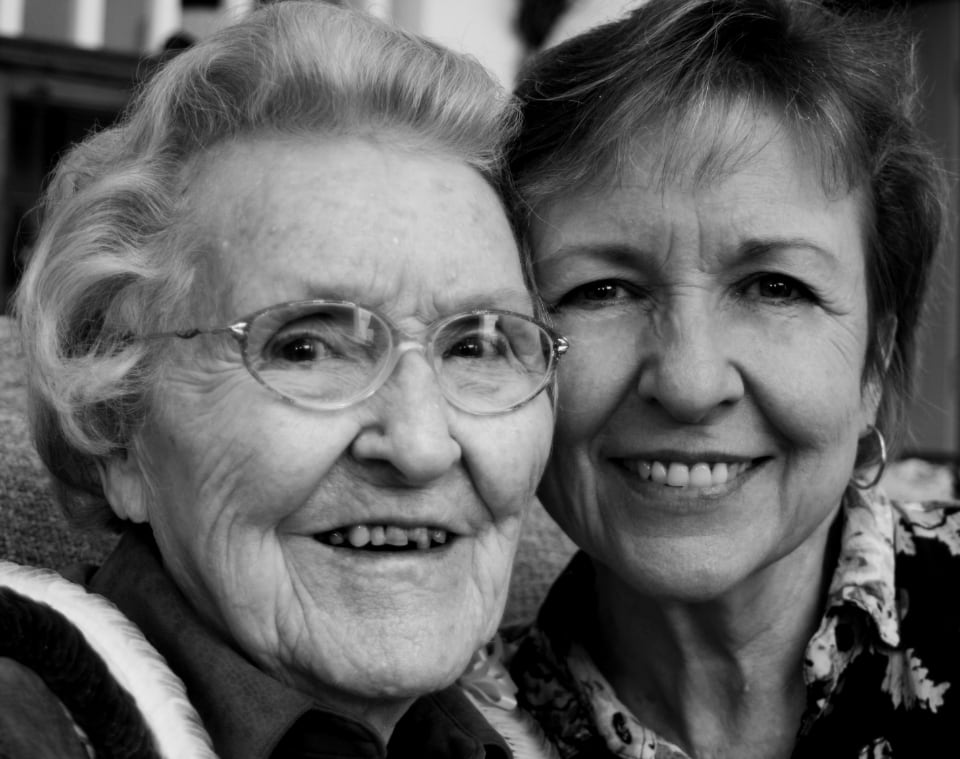Black-and-white portrait of two smiling older women