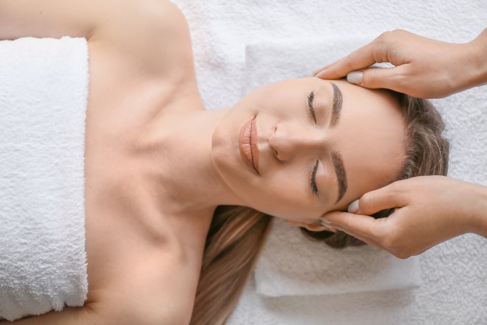 Woman relaxing with her eyes closed during a head massage