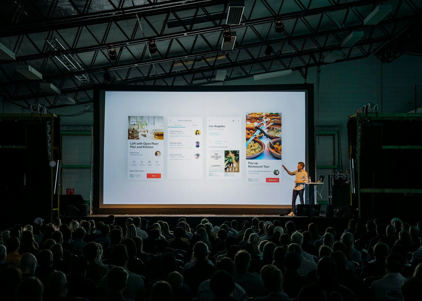 Speaker presenting on a large stage to an audience