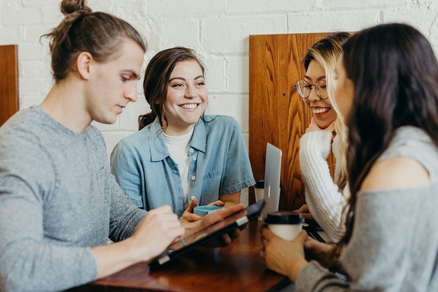 A small group studying together with laptops and coffee